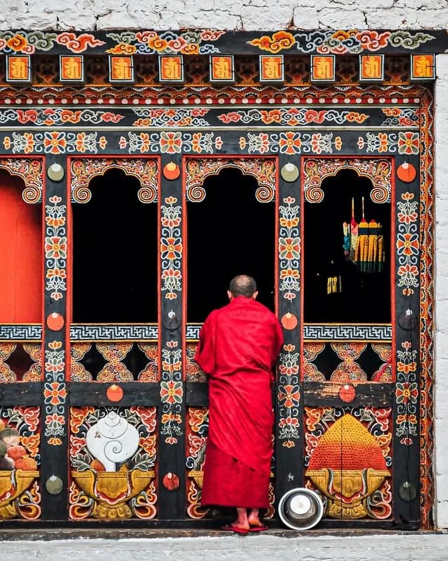Monje budista frente a templo tradicional tibetano